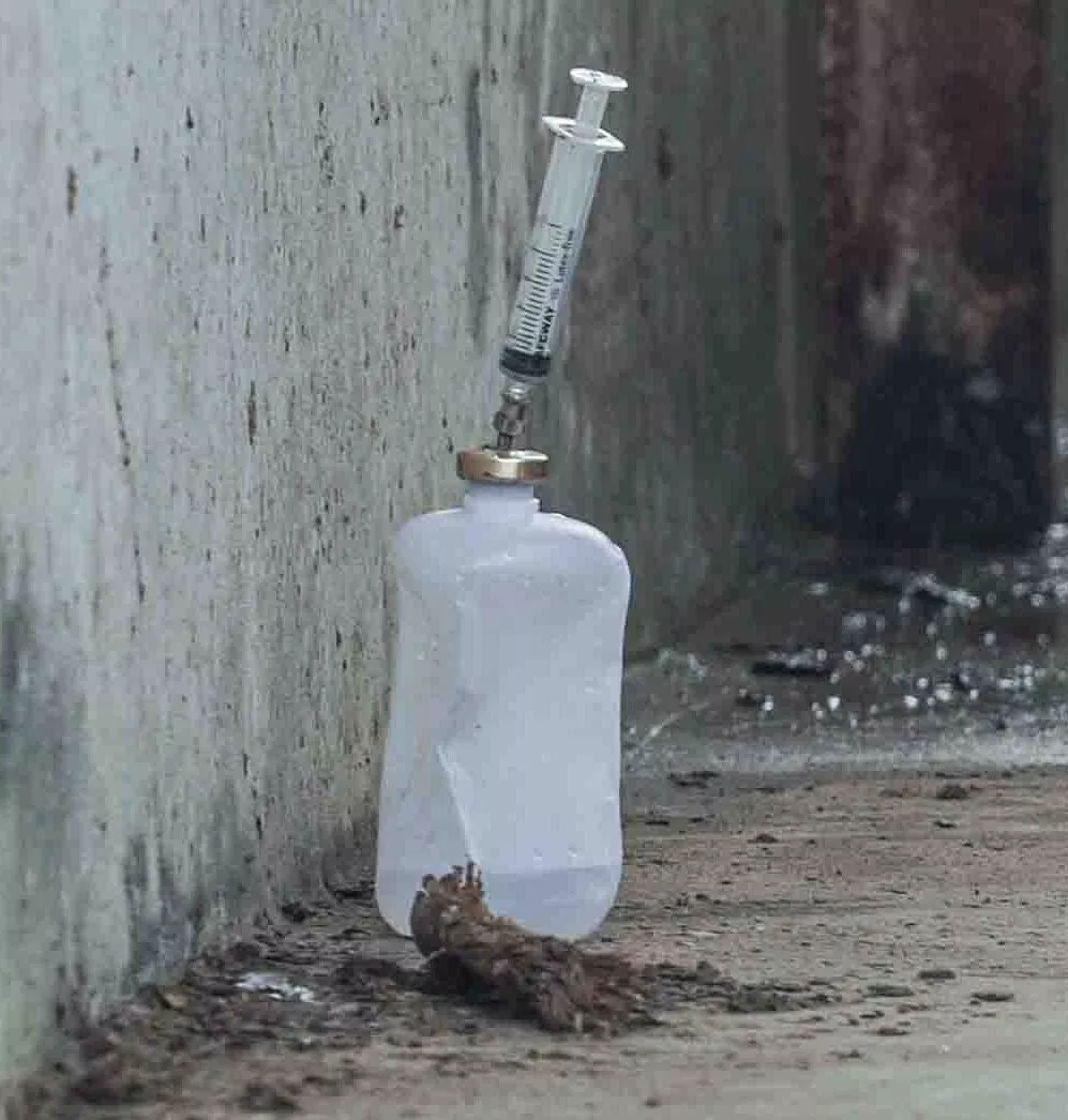 a bottle of Oxytocin on a dirty ledge with a needle stuck in the top